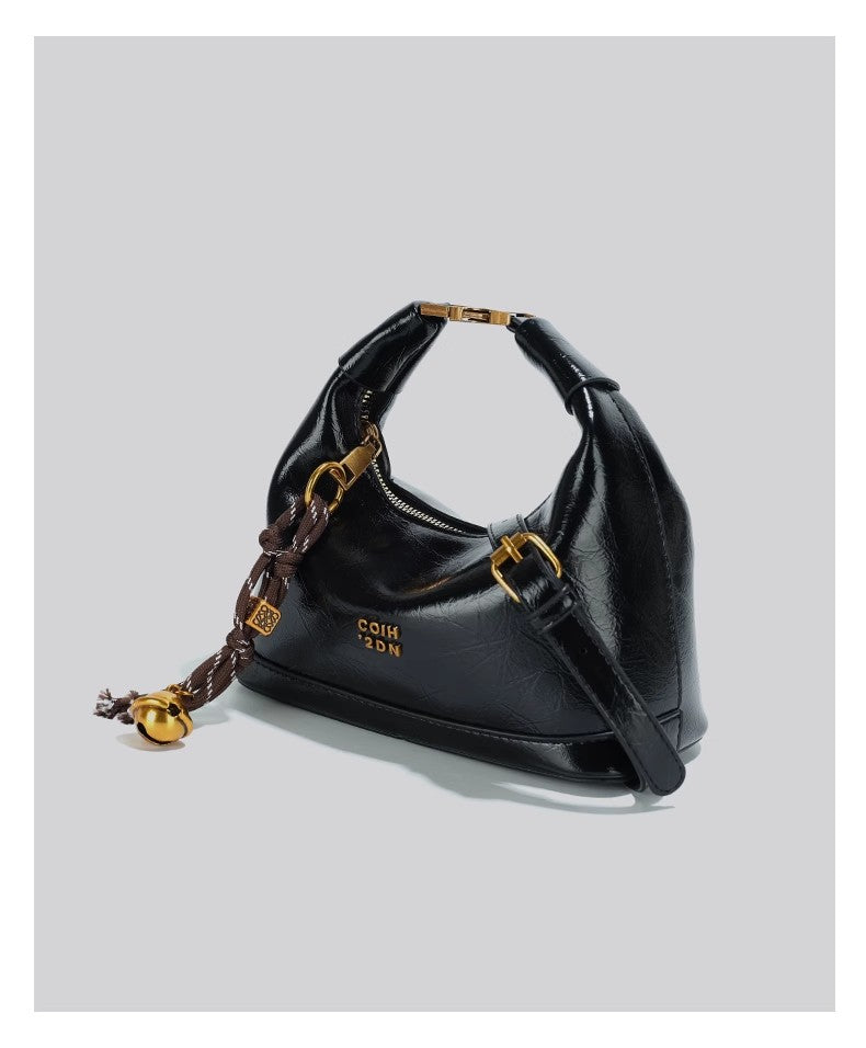 斜め掛けのバッグを手にしていますA niche small handbag carried diagonally across the body
