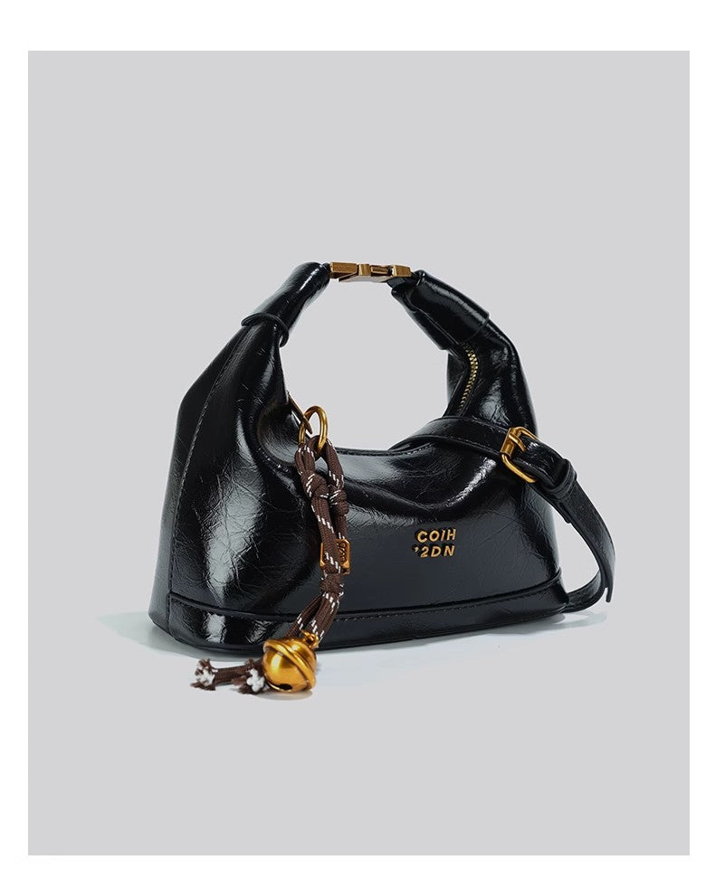 斜め掛けのバッグを手にしていますA niche small handbag carried diagonally across the body